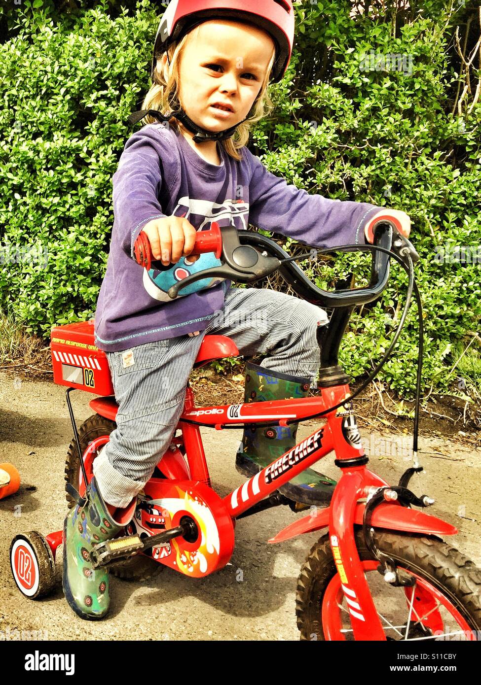 Boy on bike with stabilisers. Stock Photo