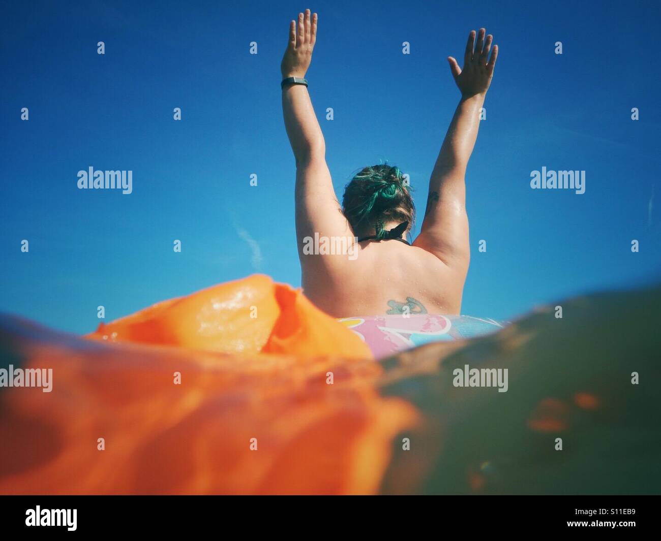 young woman with her outstretched arms in the water in summer - Smartphone Captured Stock Image