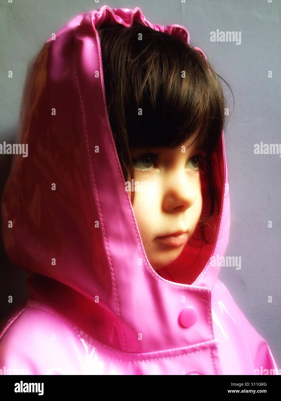 4-year old girl waiting for the summer rain to stop, Bawdsey, Suffolk, UK. - Smartphone Captured Stock Image