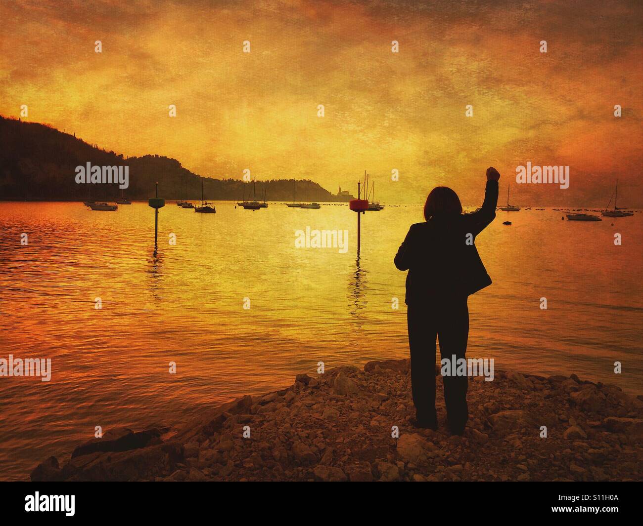 Silhouette of a woman standing on the beach at sunset Stock Photo - Alamy