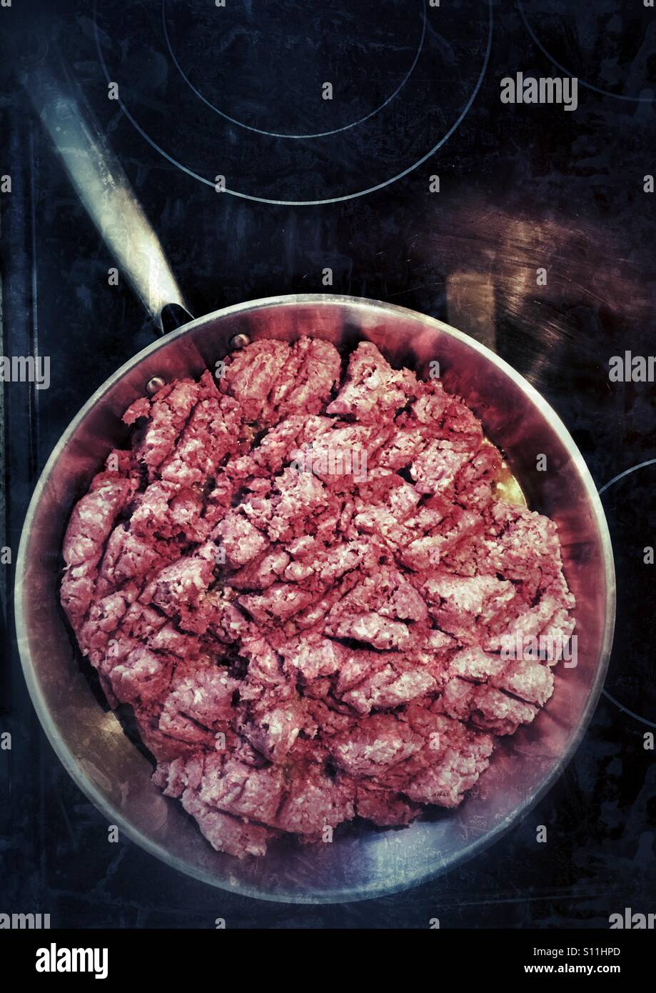 Frying pan on stove full of ground beef Stock Photo