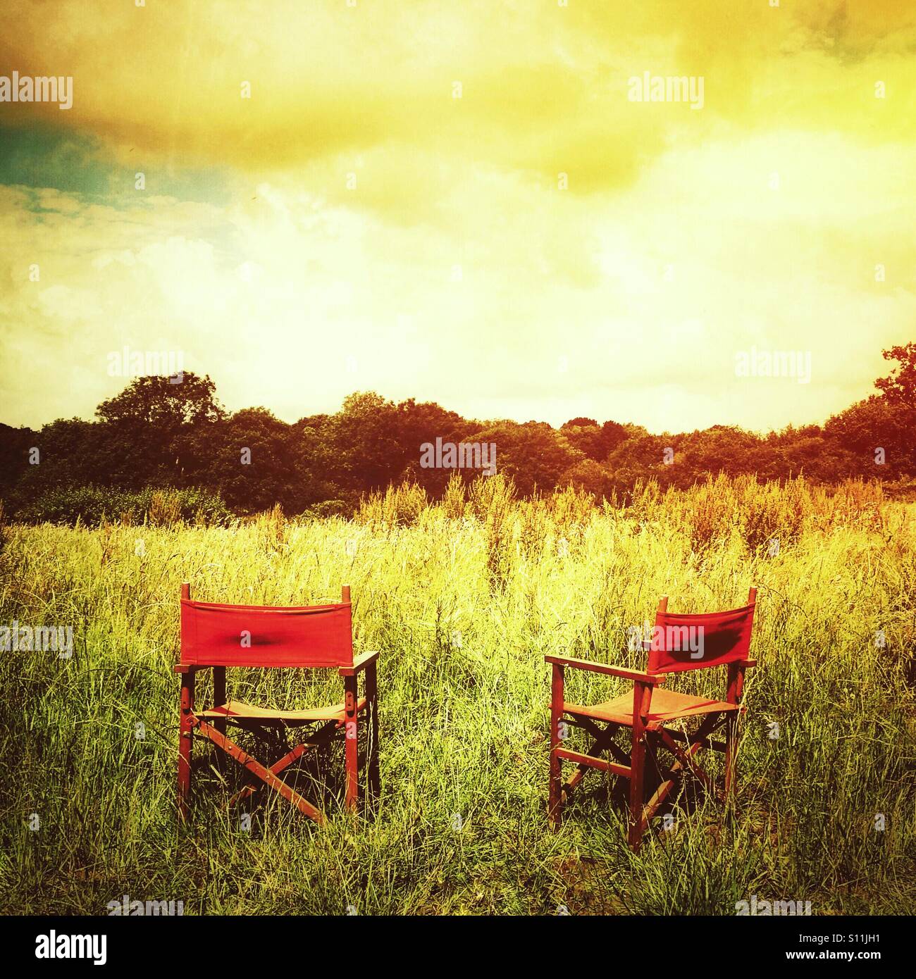 Pair of empty chairs in field Stock Photo