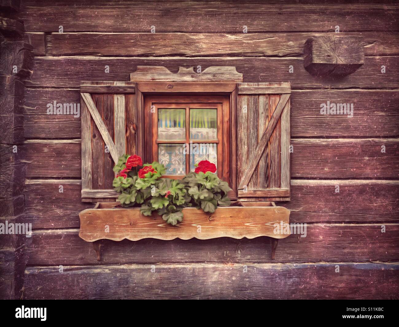 Window with geraniums on a traditional wooden cabin in Austria - Smartphone Captured Stock Image