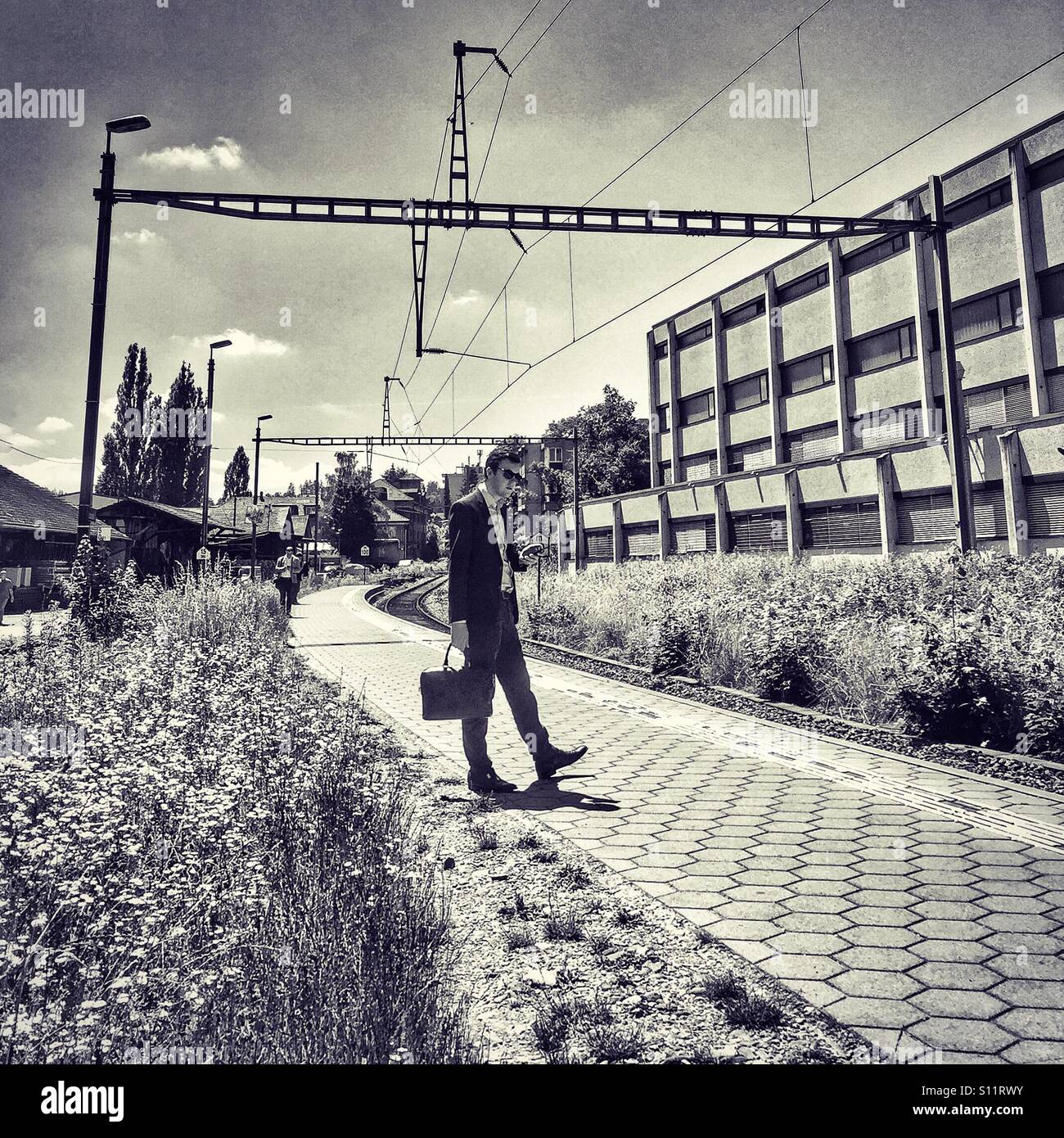 Snazzily suited commuter waiting for his train - Smartphone Captured Stock Image