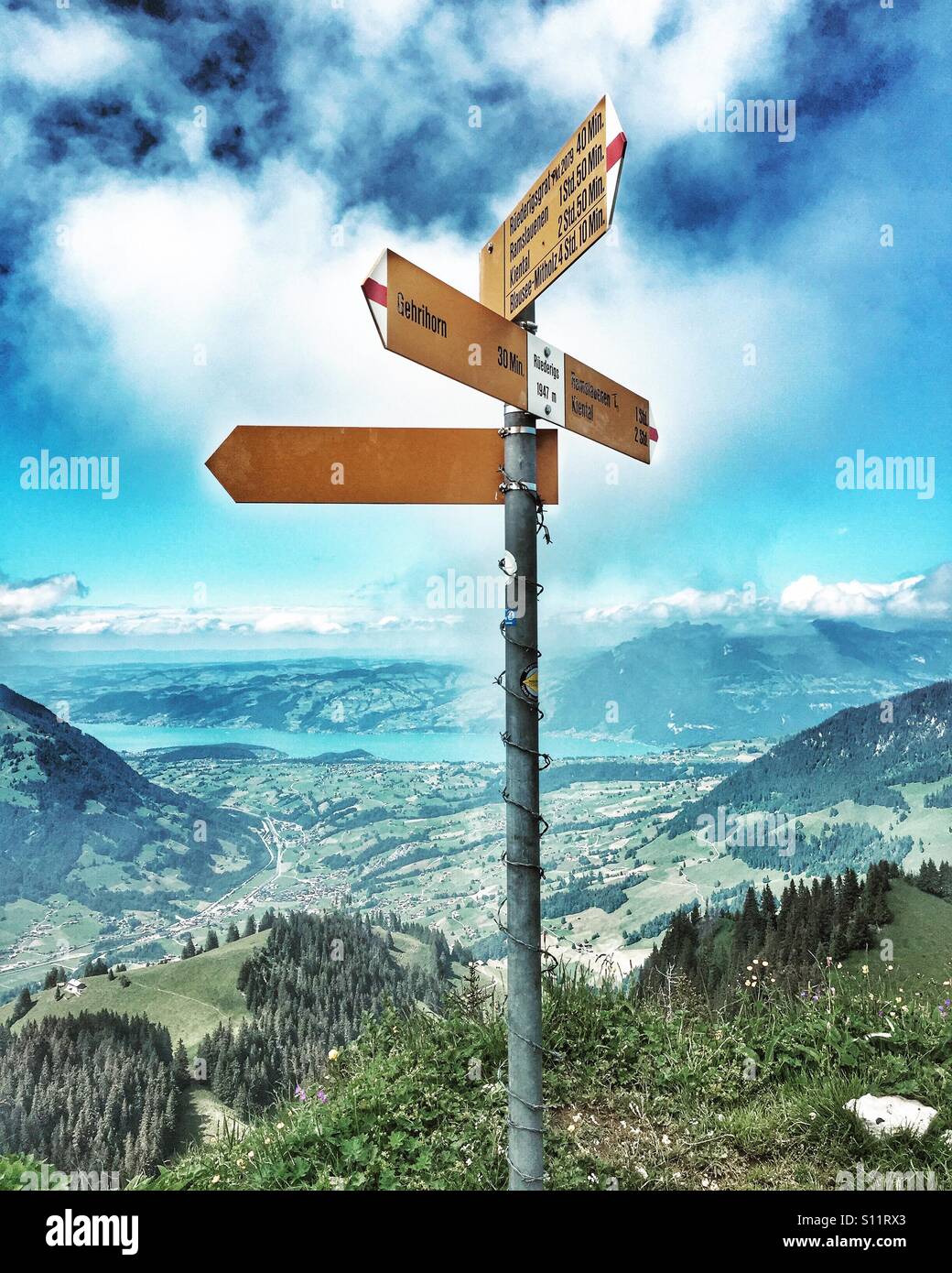Which way now? Swiss footpath signs with Lake Thun in the distance - Smartphone Captured Stock Image