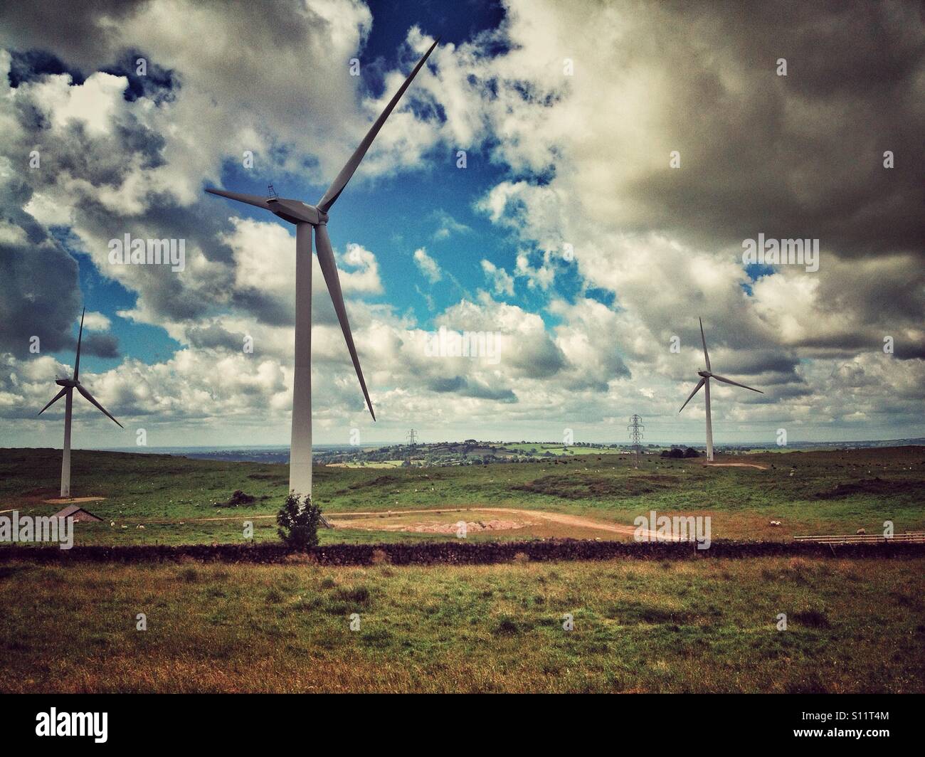 Wind turbines in uk landscape with aged filter applied. Stock Photo