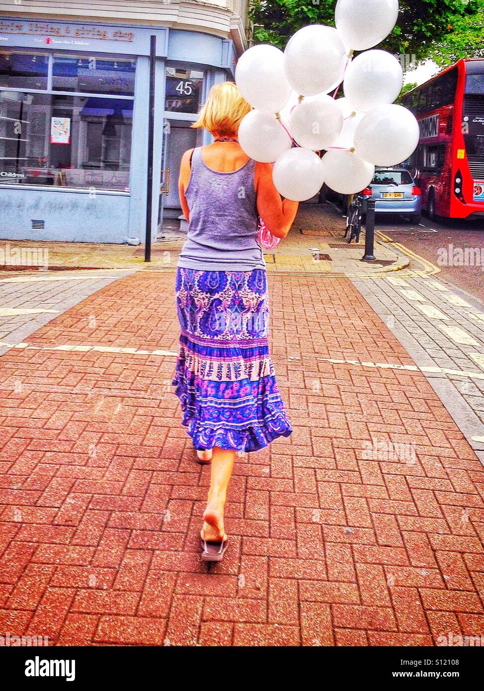 Woman walking with balloons. - Smartphone Captured Stock Image
