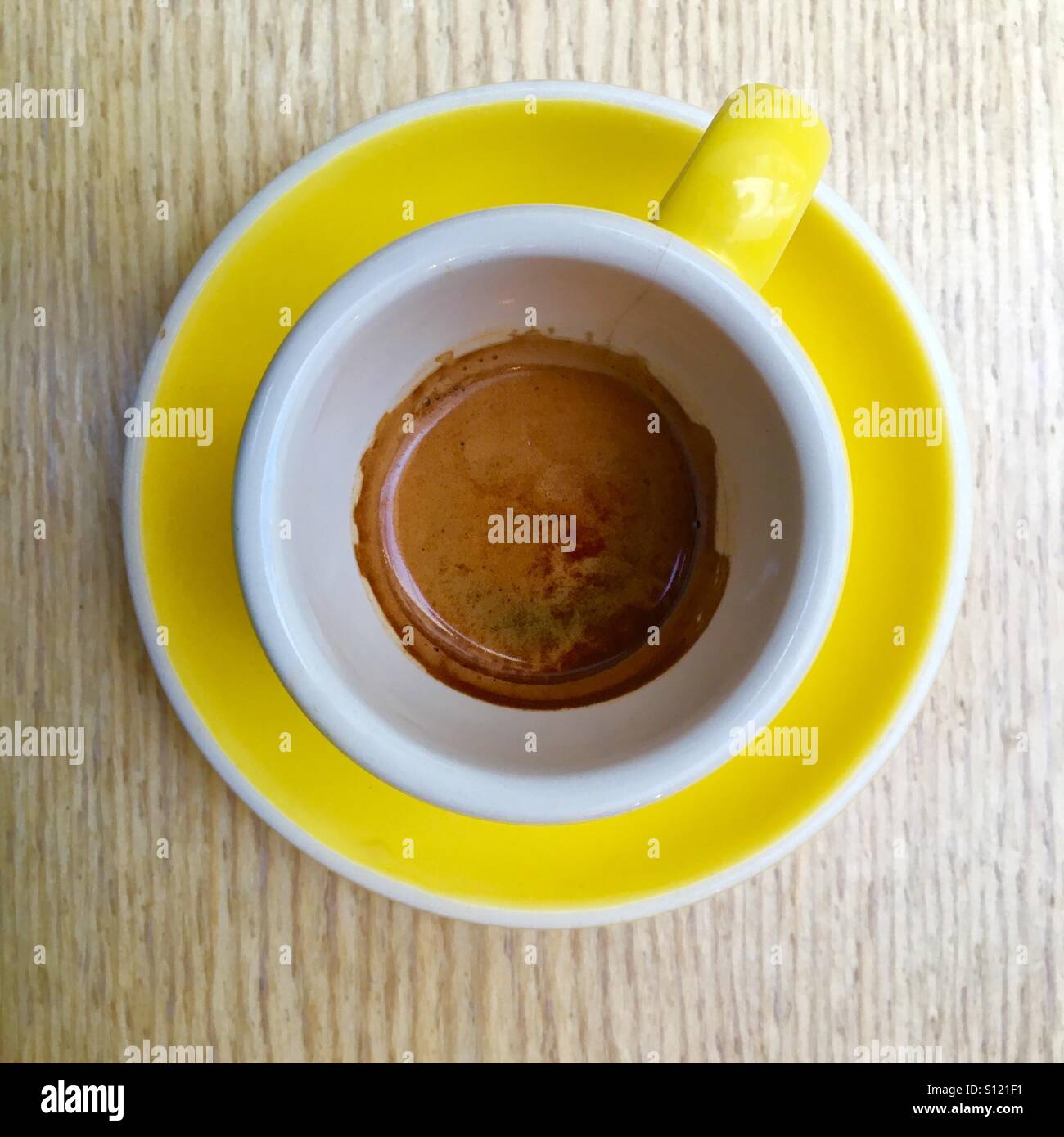 Espresso coffee in yellow cup and saucer - Smartphone Captured Stock Image
