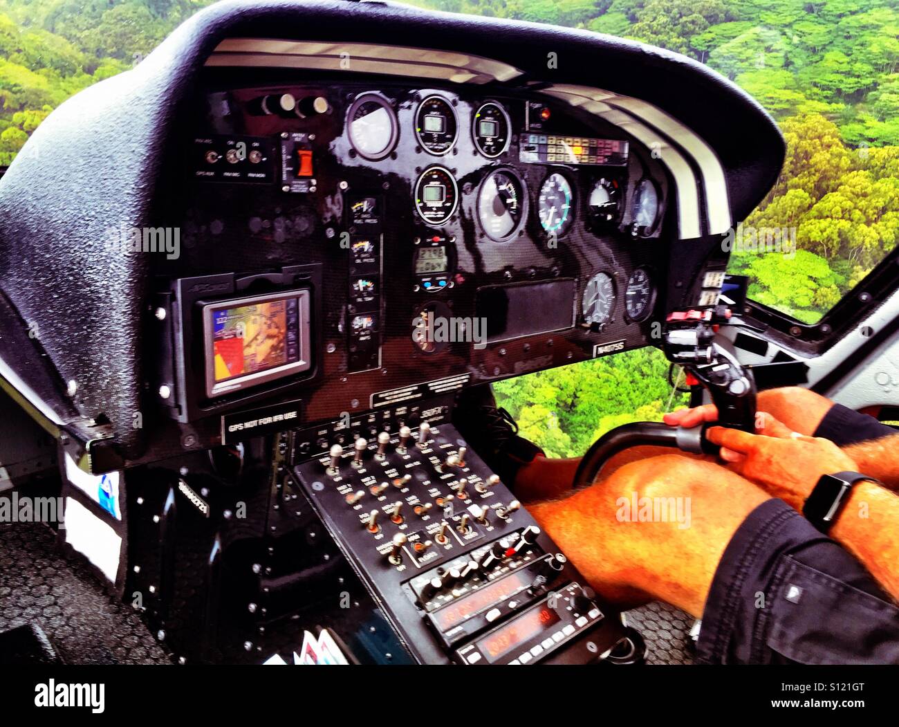 Helicopter flight dashboard and pilot over jungle canopy - Smartphone Captured Stock Image