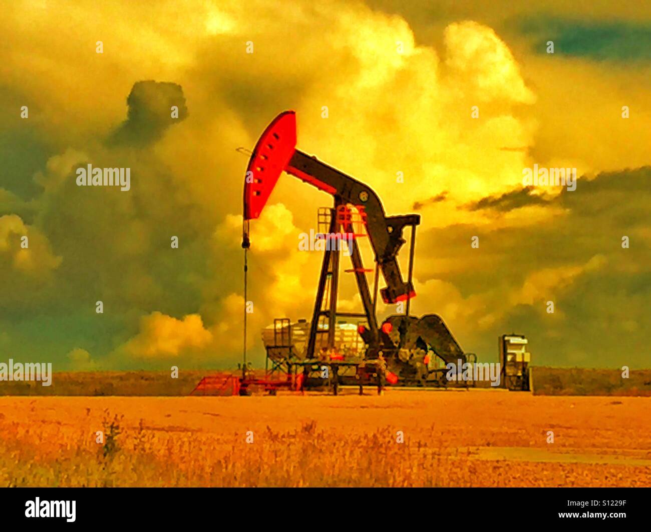 Red and black oil well pump jack - Smartphone Captured Stock Image