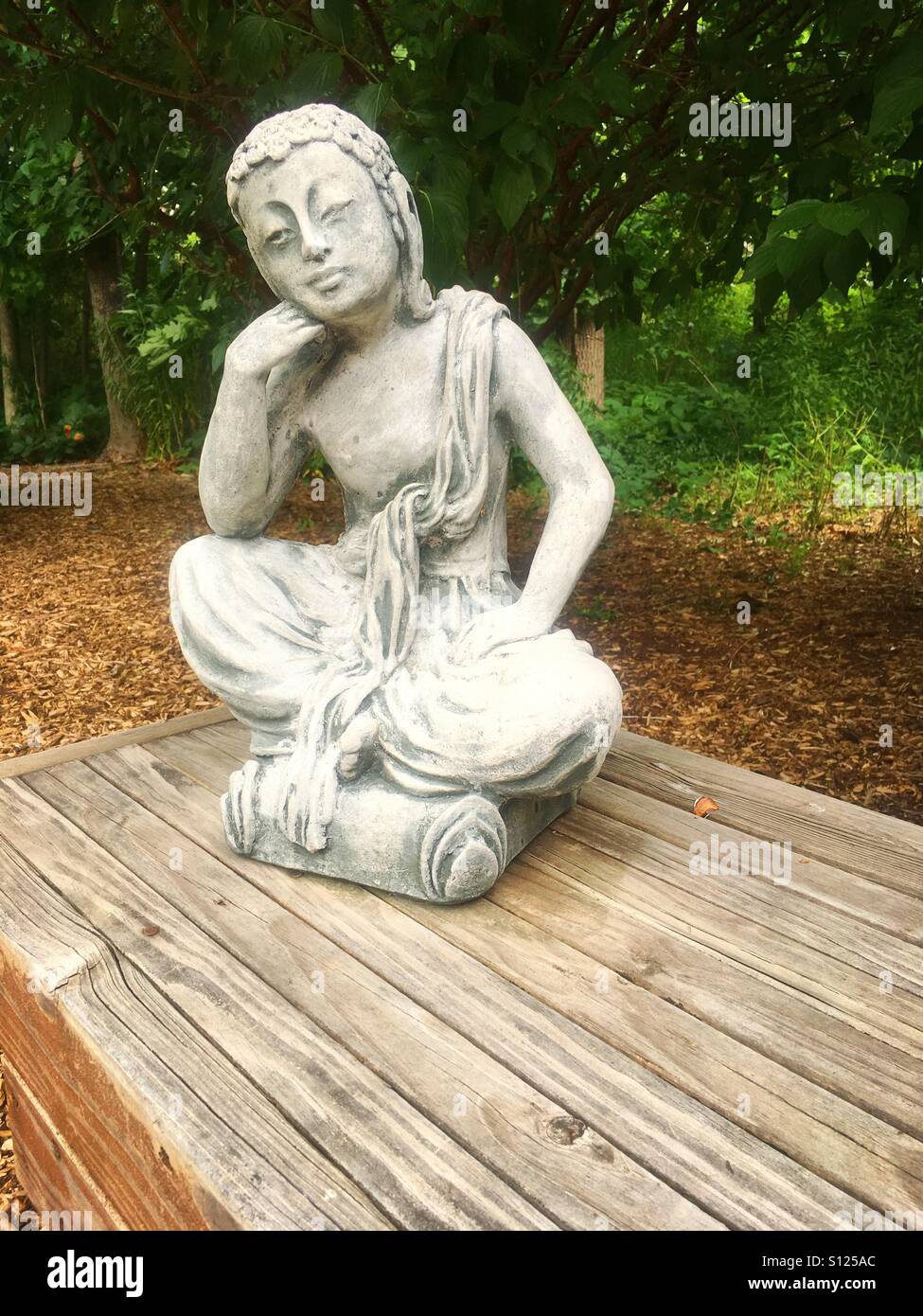 Statue on a bench in a garden Stock Photo Alamy