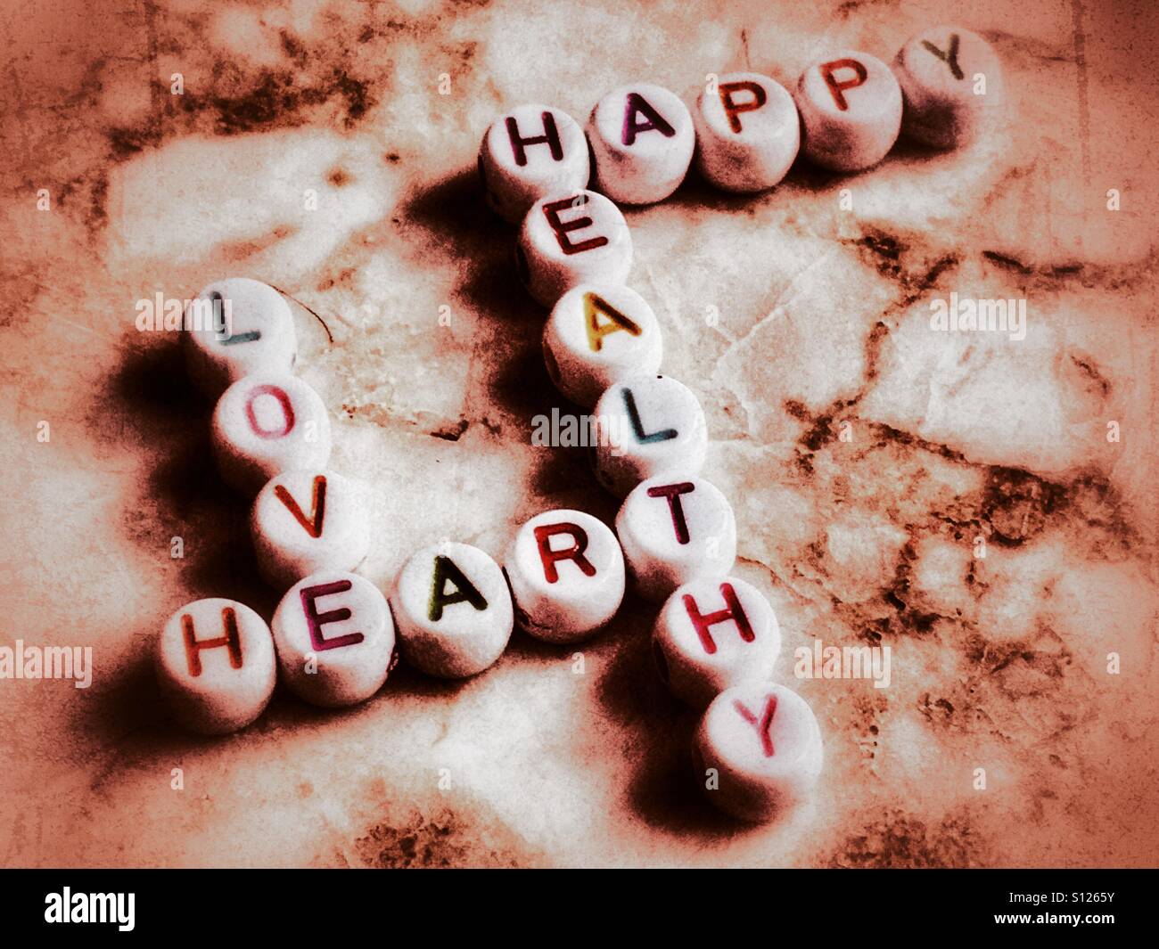Crossword made of beads, spelling the words love, heart, healthy, happy - Smartphone Captured Stock Image
