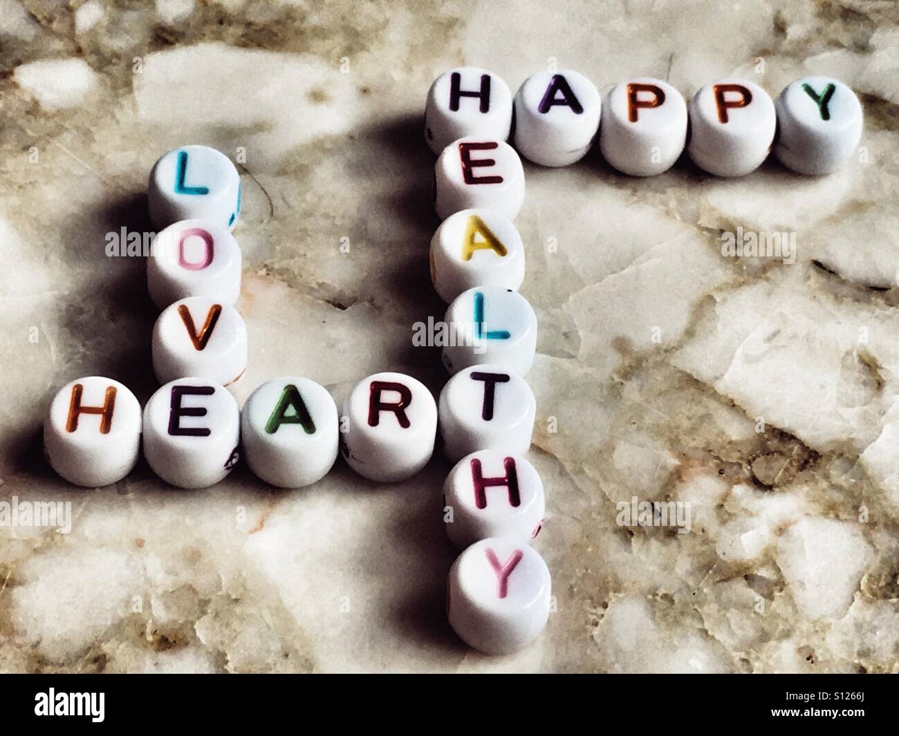 Crossword made of beads spelling the words love, heart, healthy, happy. - Smartphone Captured Stock Image