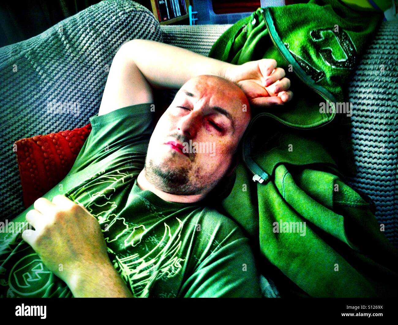 A man asleep on a sofa. - Smartphone Captured Stock Image