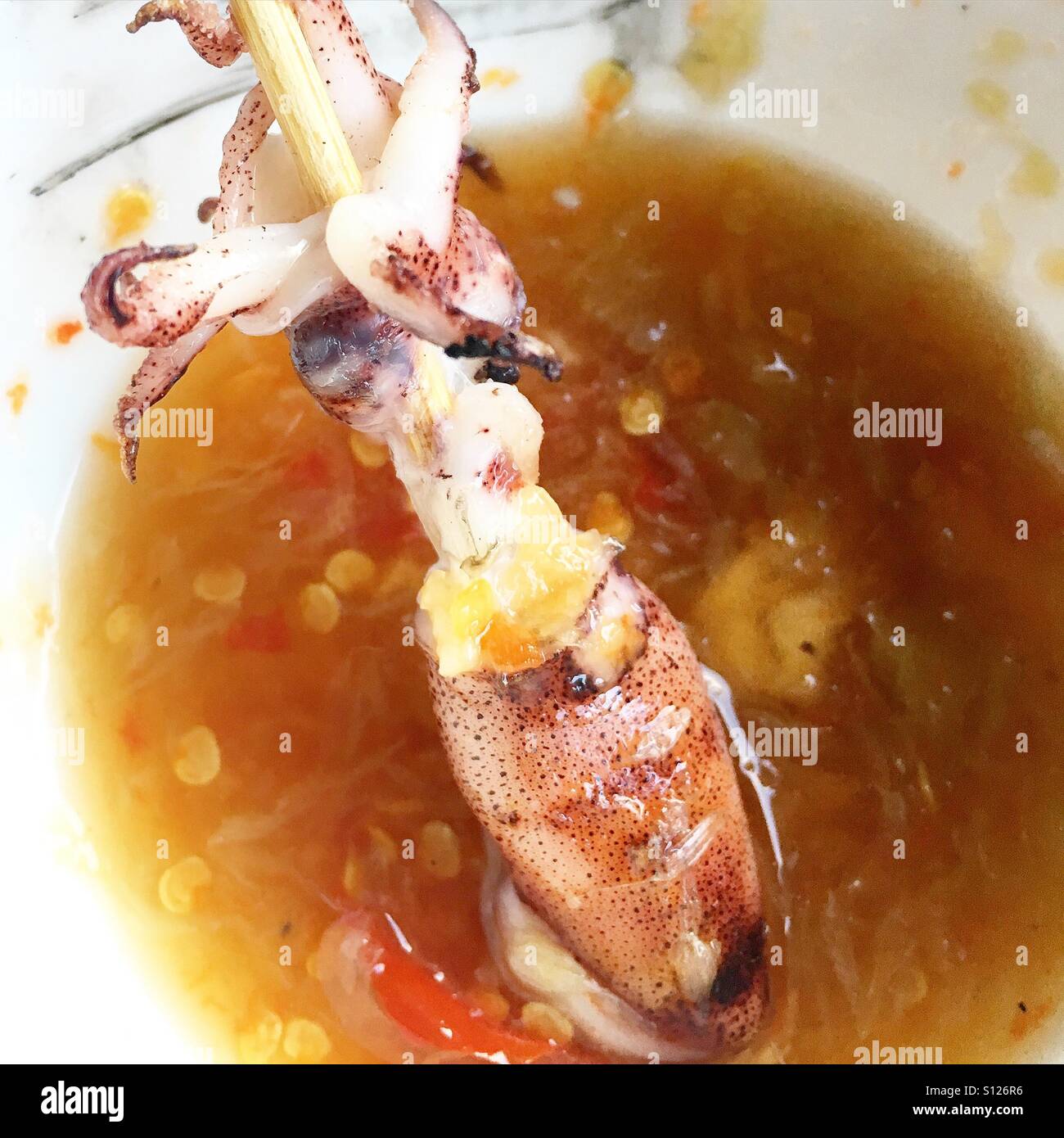 BBQ Baby squid on skewer dipped in chilli fish sauce Stock Photo Alamy