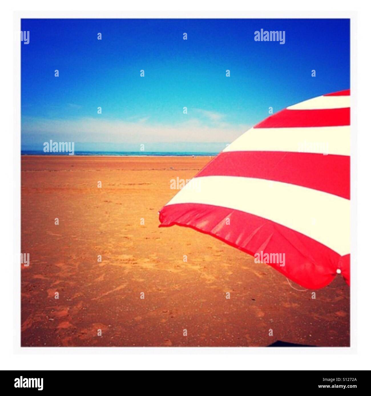 Red and white parasol on beach Stock Photo - Alamy