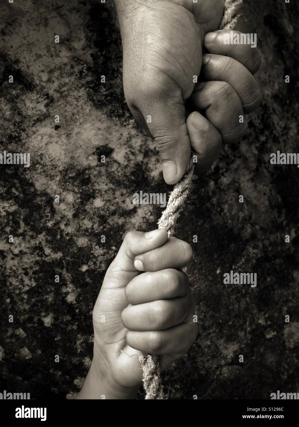 Two hands holding a rope Stock Photo