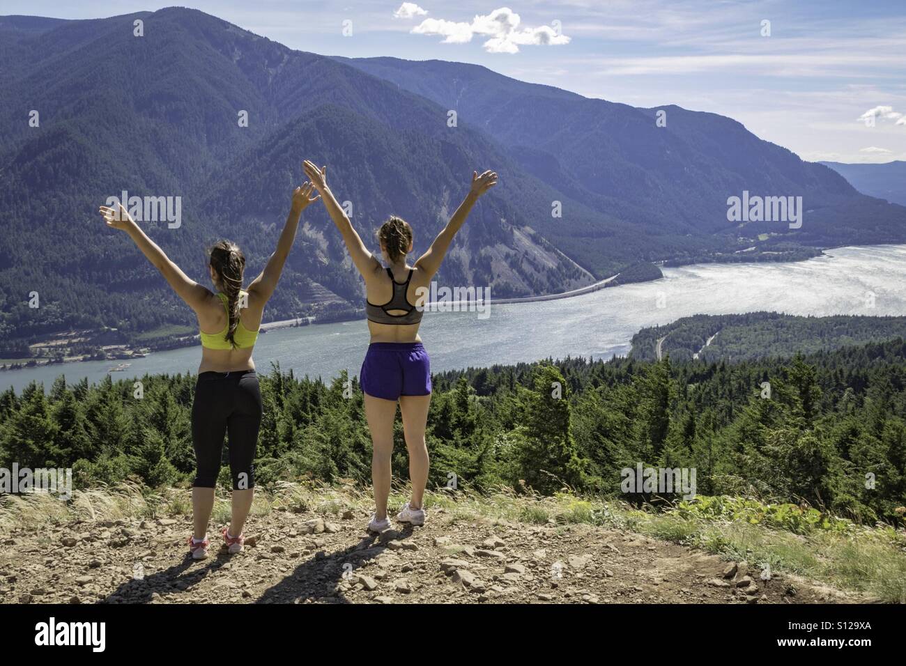 Two young women worshiping the sun at Lookout #1 on Dog Mountain. - Smartphone Captured Stock Image