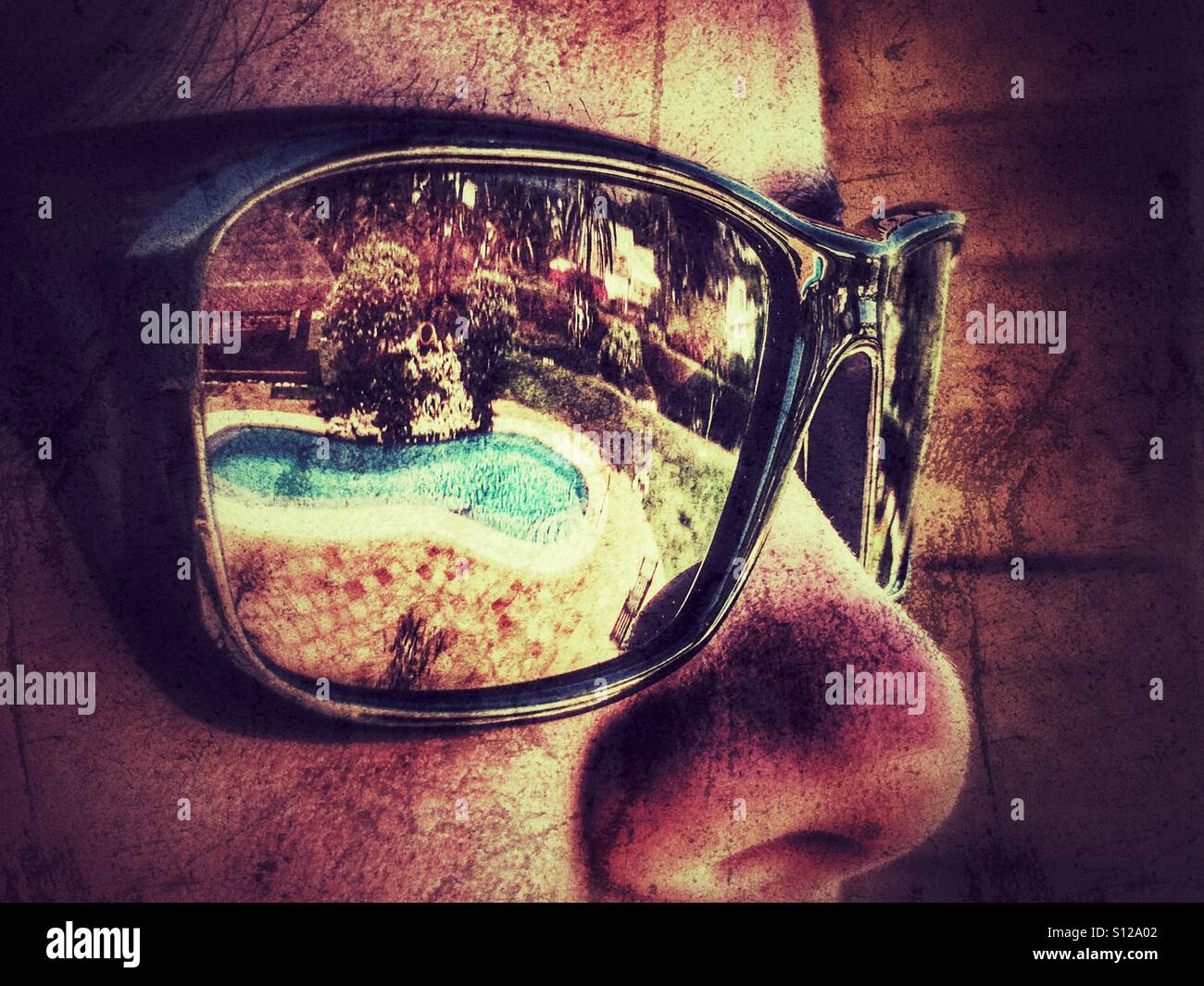 Woman wearing reflective shades, looking at swimming pool in summer - Smartphone Captured Stock Image