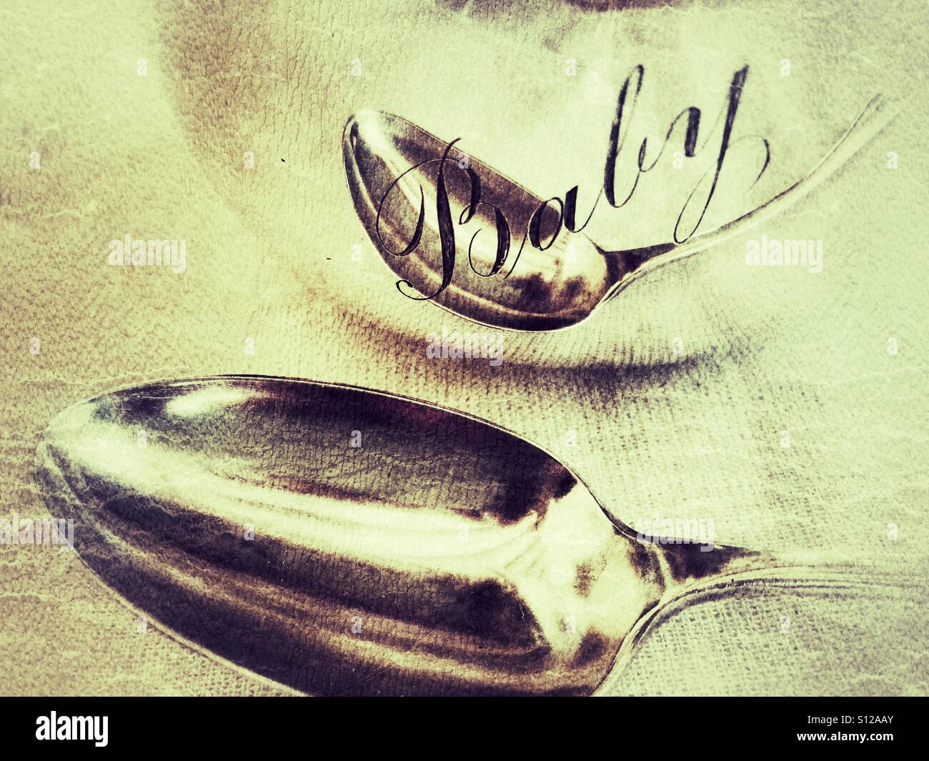 Antique sterling silver spoon and reflection in a silver bowl with the word 'baby' engraved on it, illustrating to have 'been born with a silver spoon'. - Smartphone Captured Stock Image