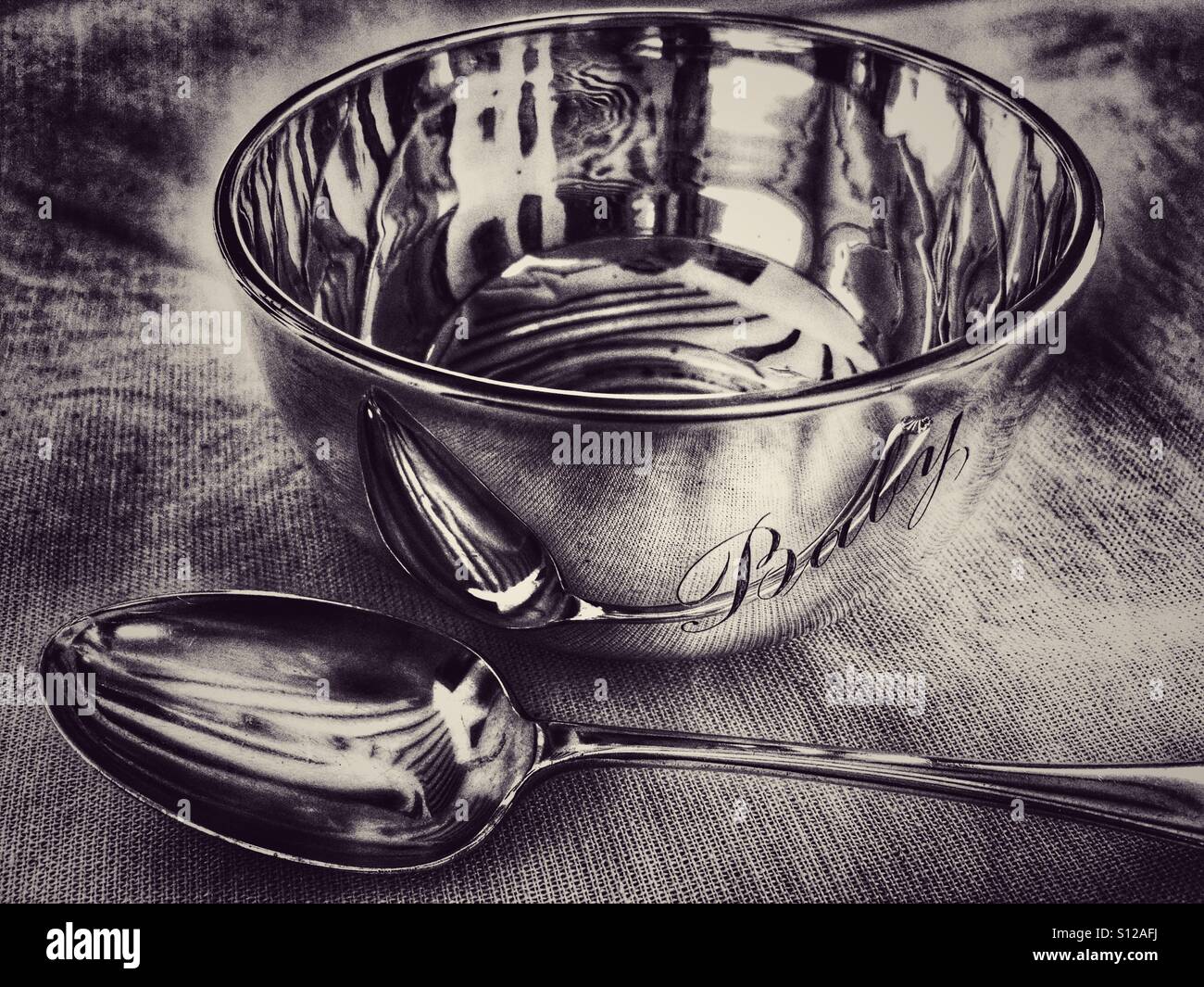 Antique sterling silver spoon and bowl with "baby" engraved on it, illustrating the phrase to