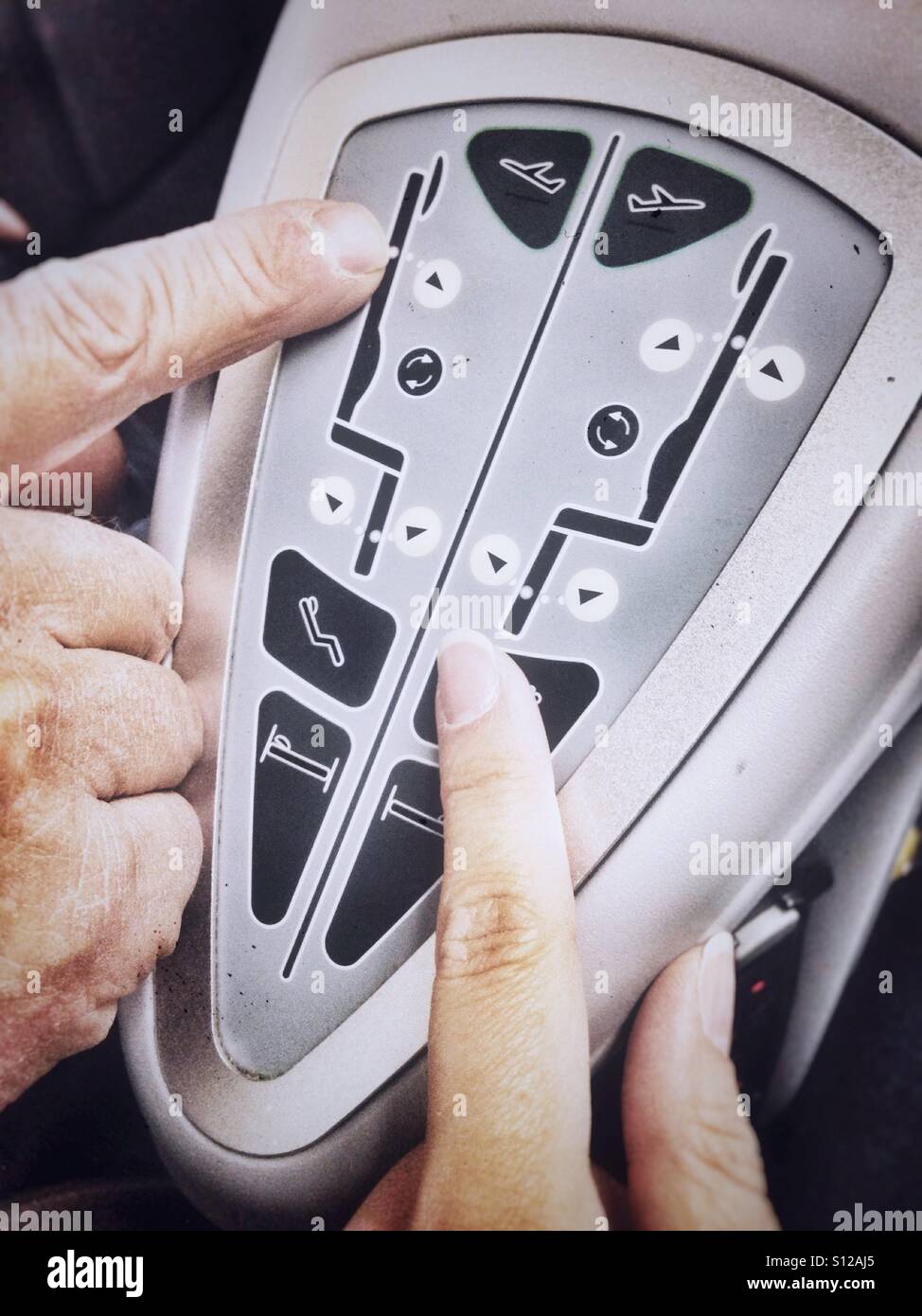 First class in an airplane, pushing buttons of full-flat seats control panel - Smartphone Captured Stock Image