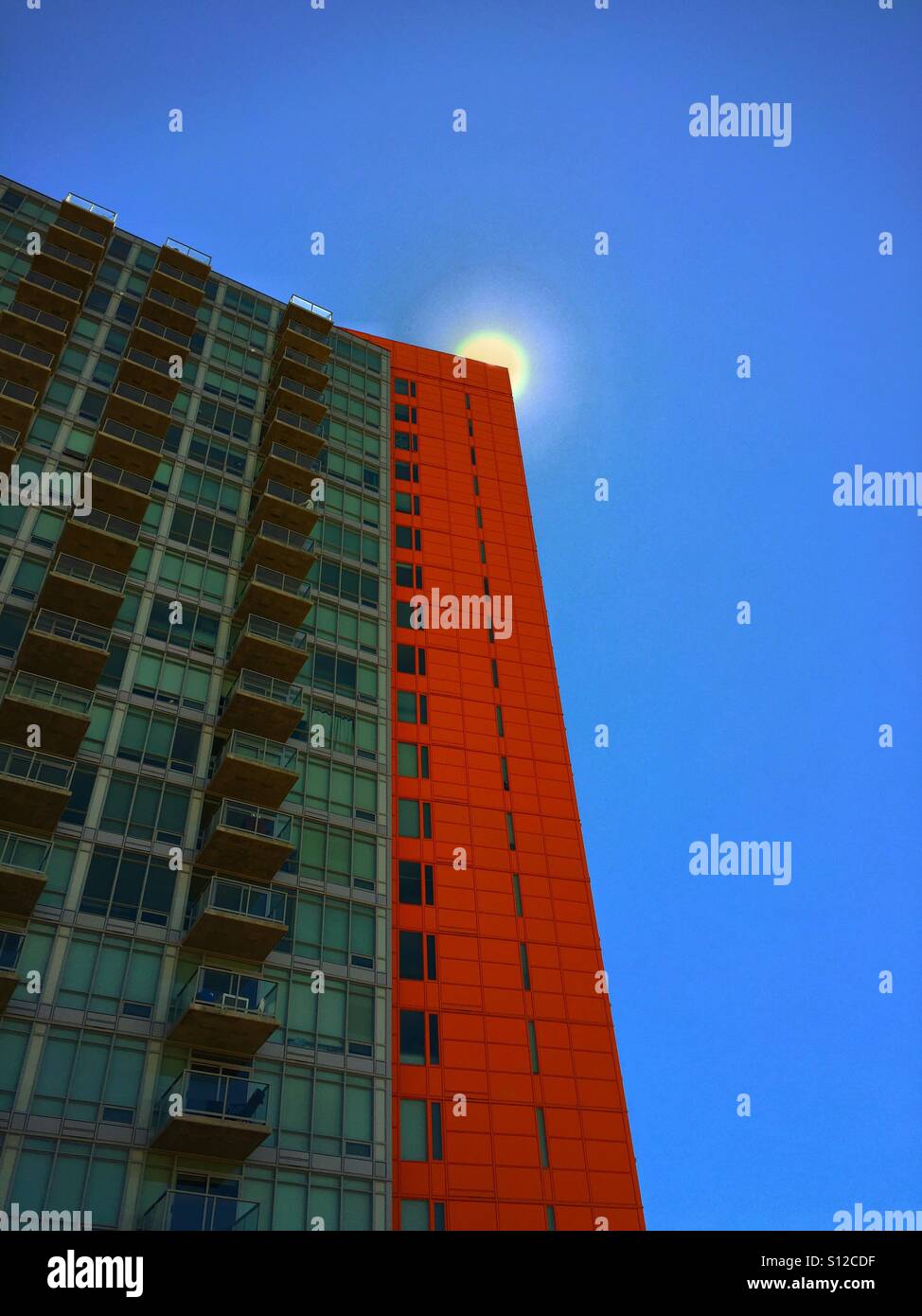 High rise condo with the sun appearing over the top corner - Smartphone Captured Stock Image