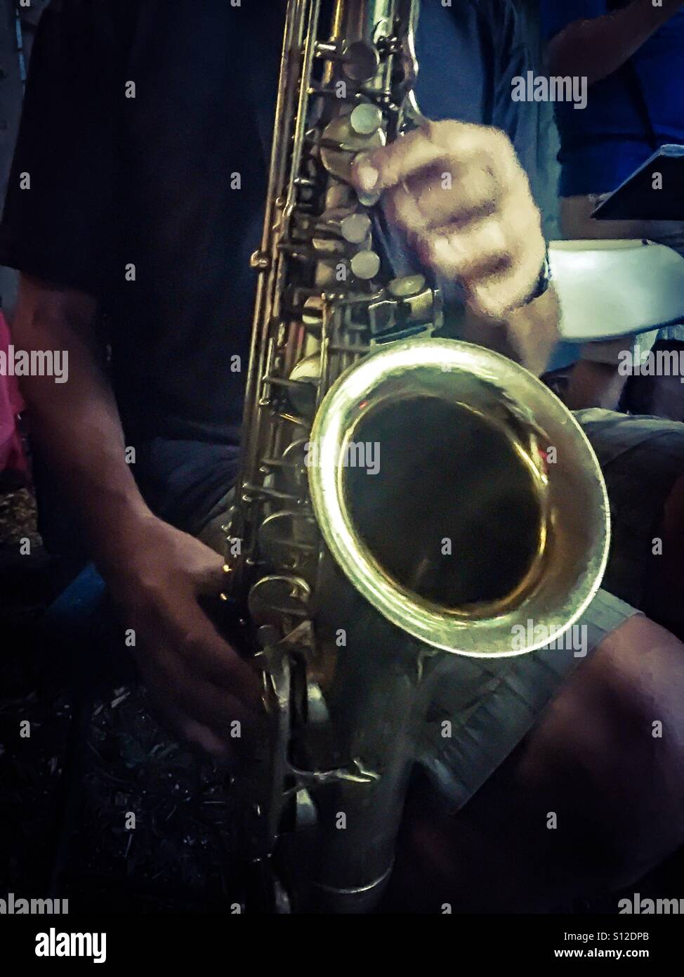 Saxophone player playing a solo riff with fast moving fingers, Ontario, Canada. Concepts: music, power of one, creative, creativity, euphony. Vibes. - Smartphone Captured Stock Image