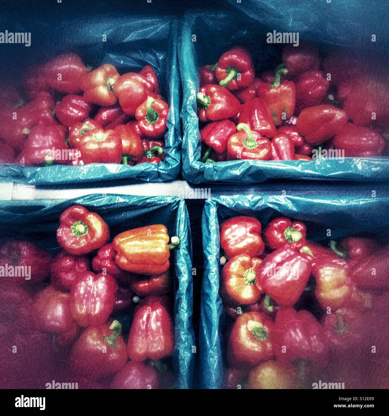 Boxes of red bell peppers displayed in a supermarket produce section, photographed from above with a stylised, graphic composition. - Smartphone Captured Stock Image