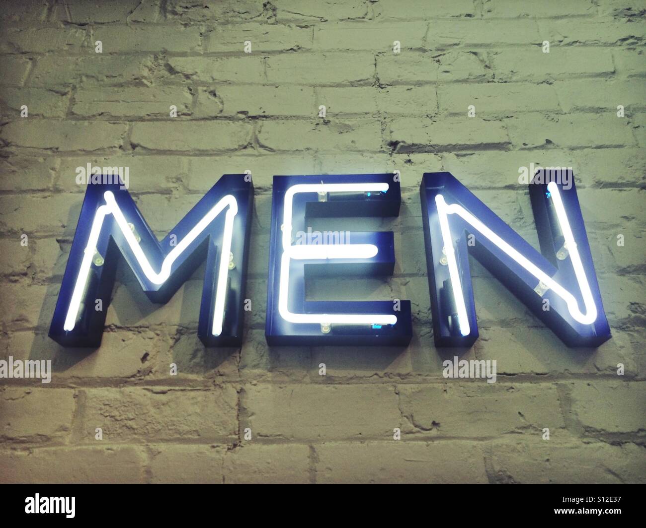 Neon Men sign on a brick wall - Smartphone Captured Stock Image