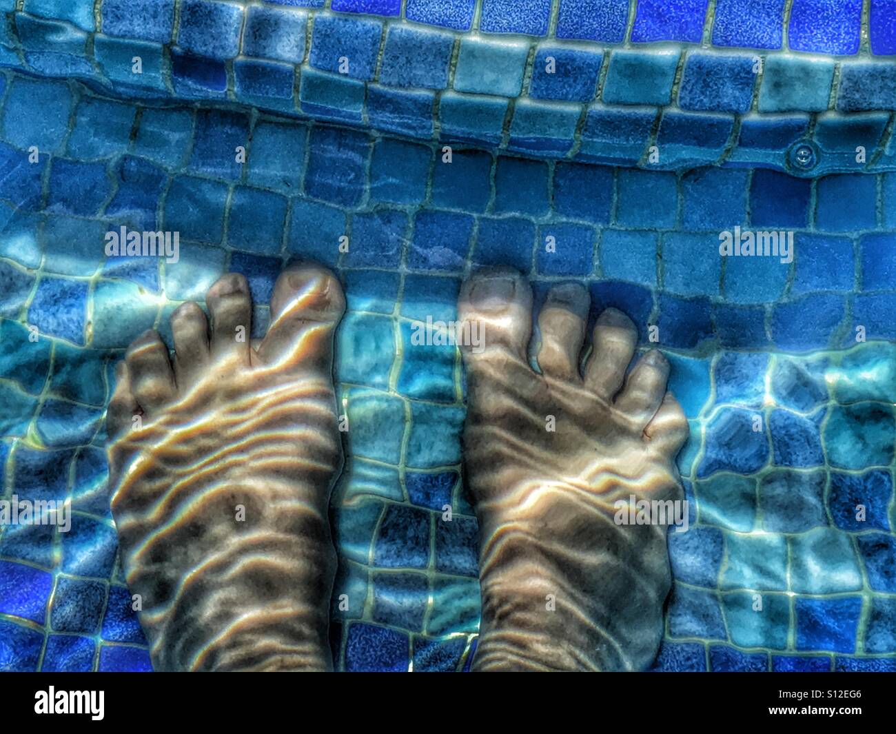 Summer fun. Feet in swimming pool. - Smartphone Captured Stock Image