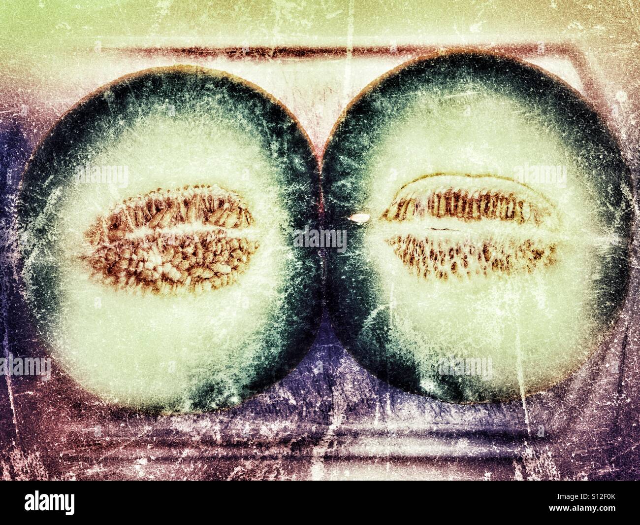 Galia melon, cut in half on a chopping board Stock Photo