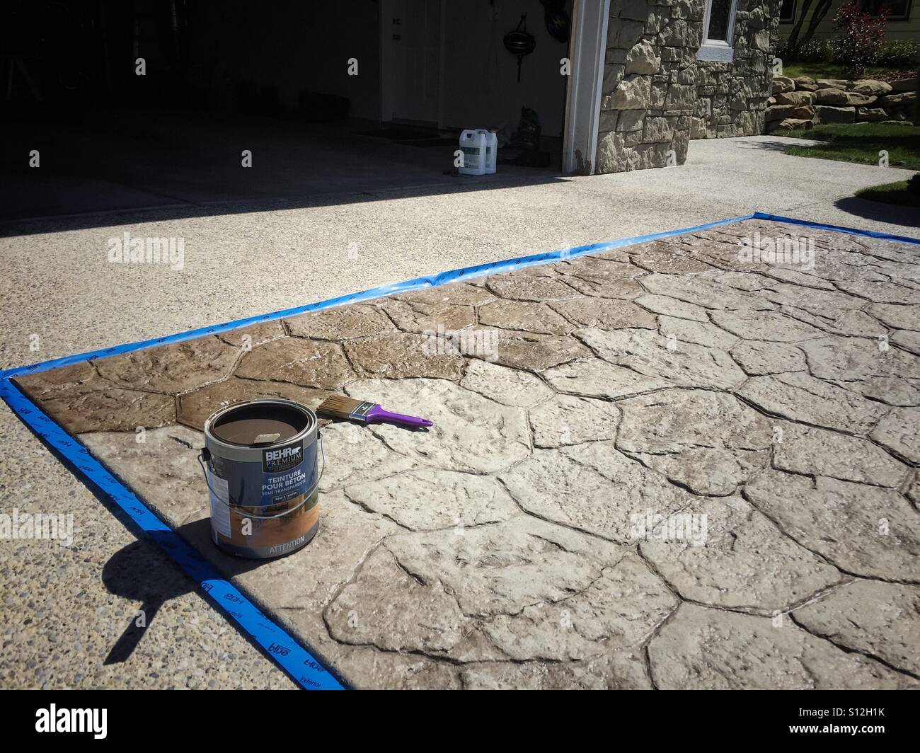 Staining the concrete of a driveway. - Smartphone Captured Stock Image