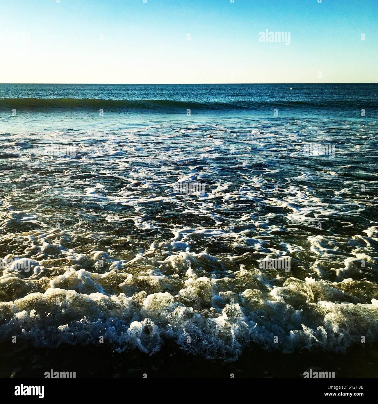 Gentle waves lapping on the seashore. - Smartphone Captured Stock Image