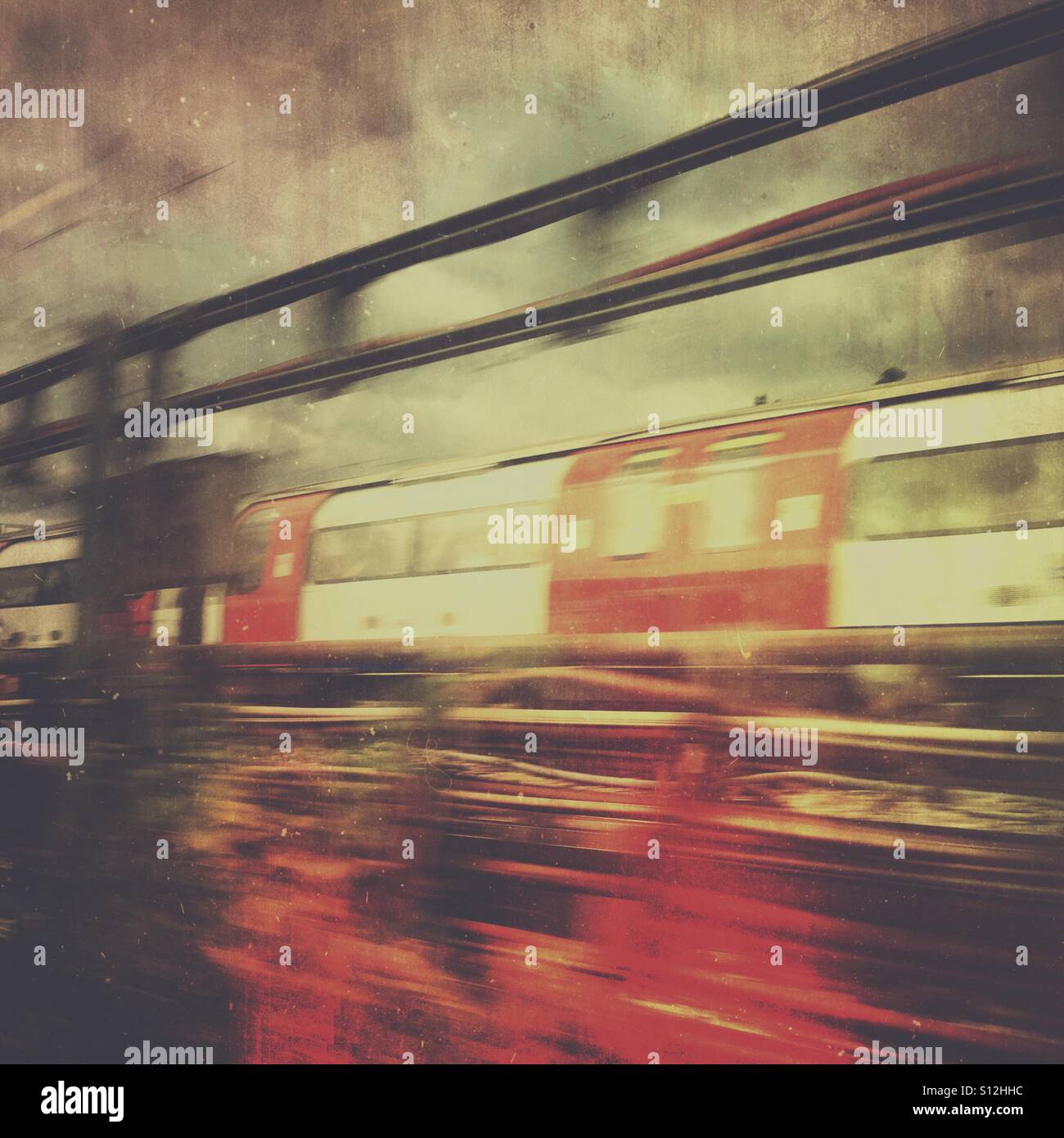 Motion-blurred commuter train on an overground section of the London rail network, creating an abstract urban transport scene with dramatic overtones. - Smartphone Captured Stock Image