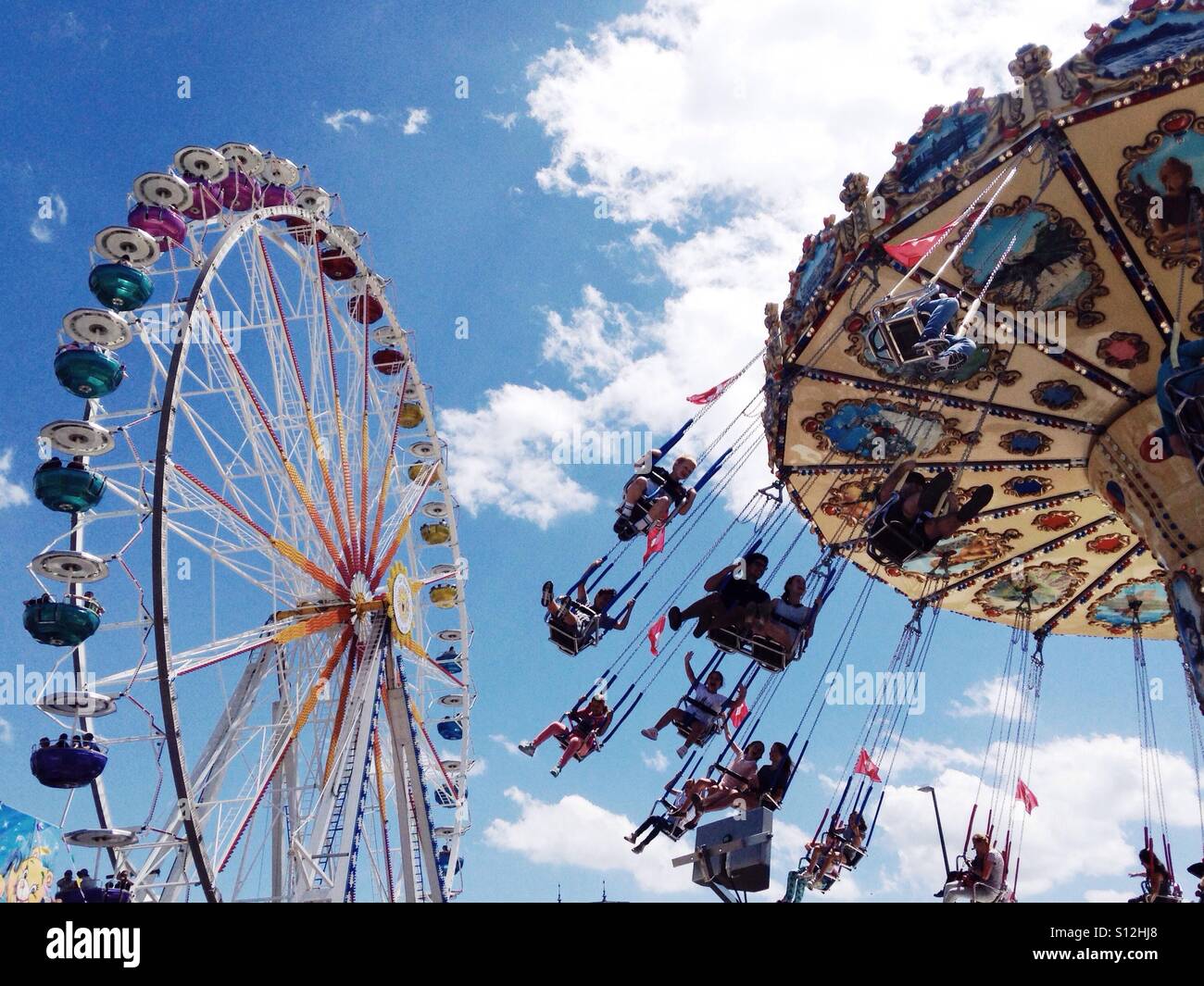 A merry-go-round and ferris wheel at a summer fair. Zurich, Switzerland. Stock Photo