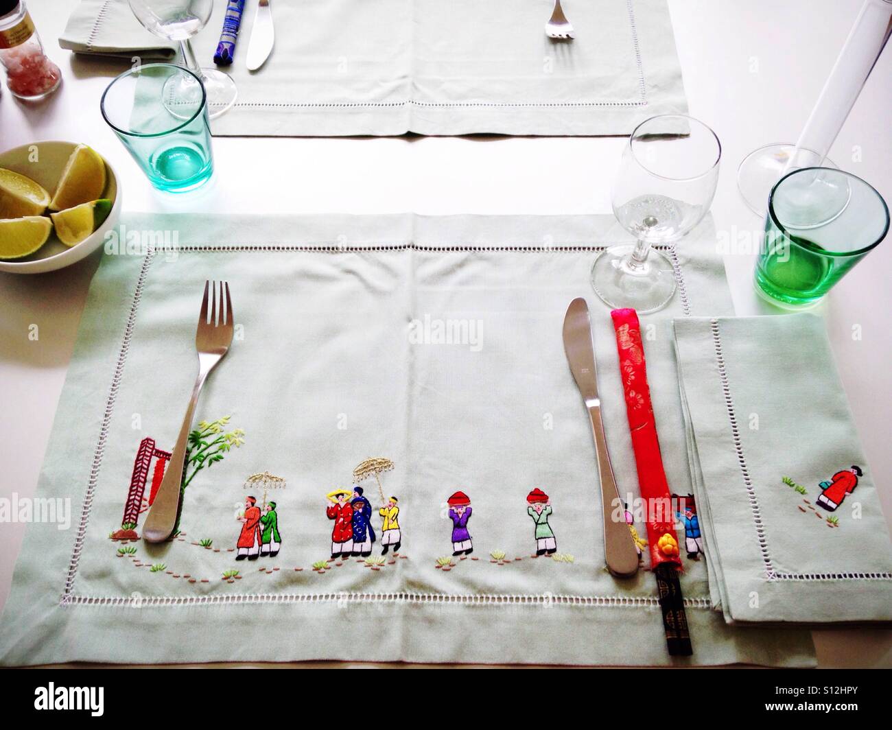 Table set with embroidered placemats and napkins depicting a