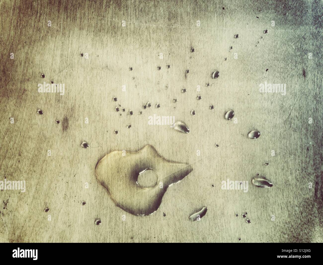A splodge of tea or another liquid on a wooden surface - Smartphone Captured Stock Image A splodge of tea or another liquid on a wooden surface - Smartphone Captured Stock Image