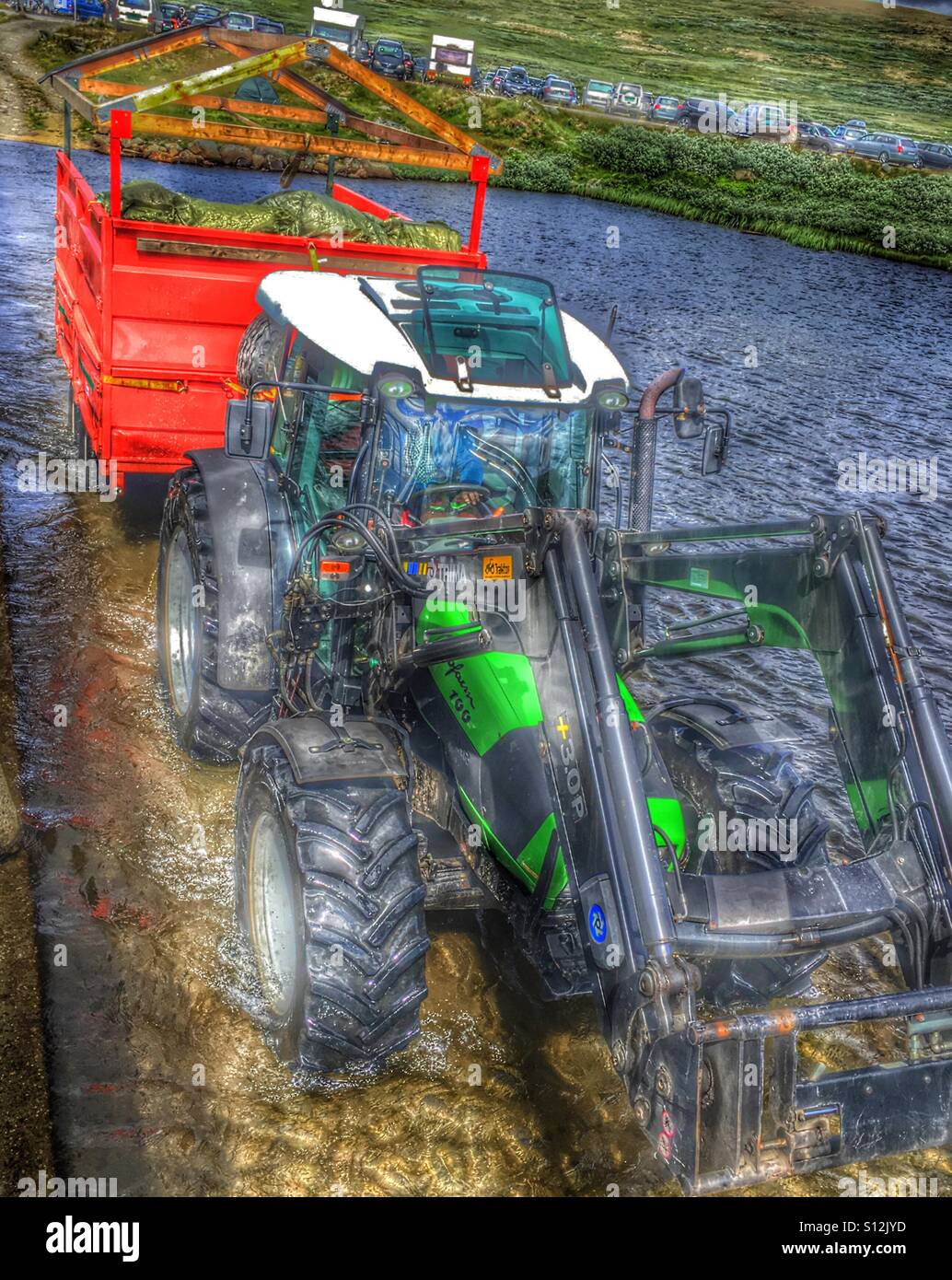 Tractor driving through a river Stock Photo Alamy