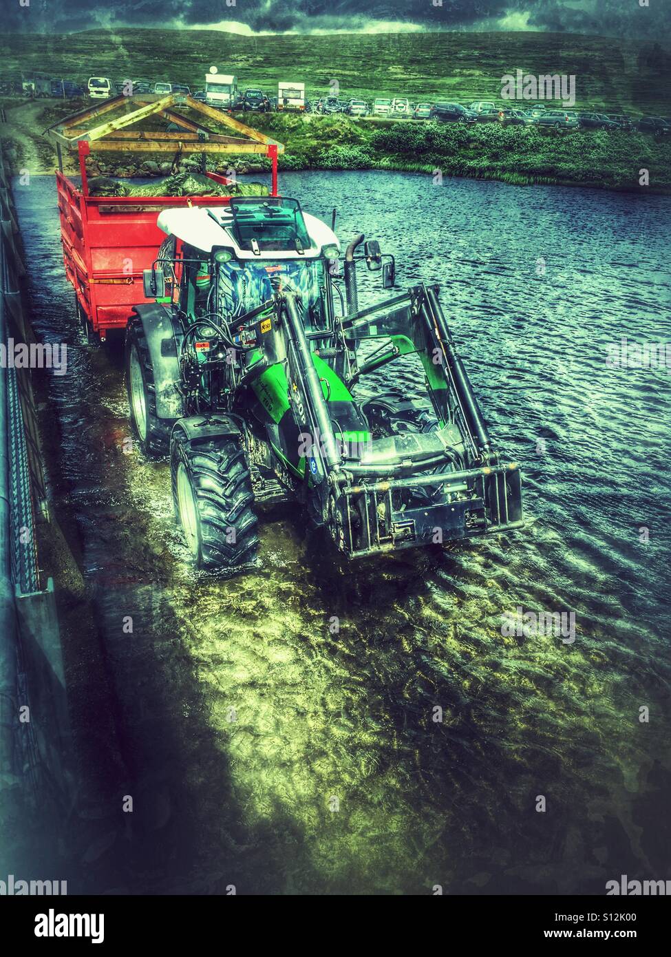 Tractor driving through a river Stock Photo Alamy