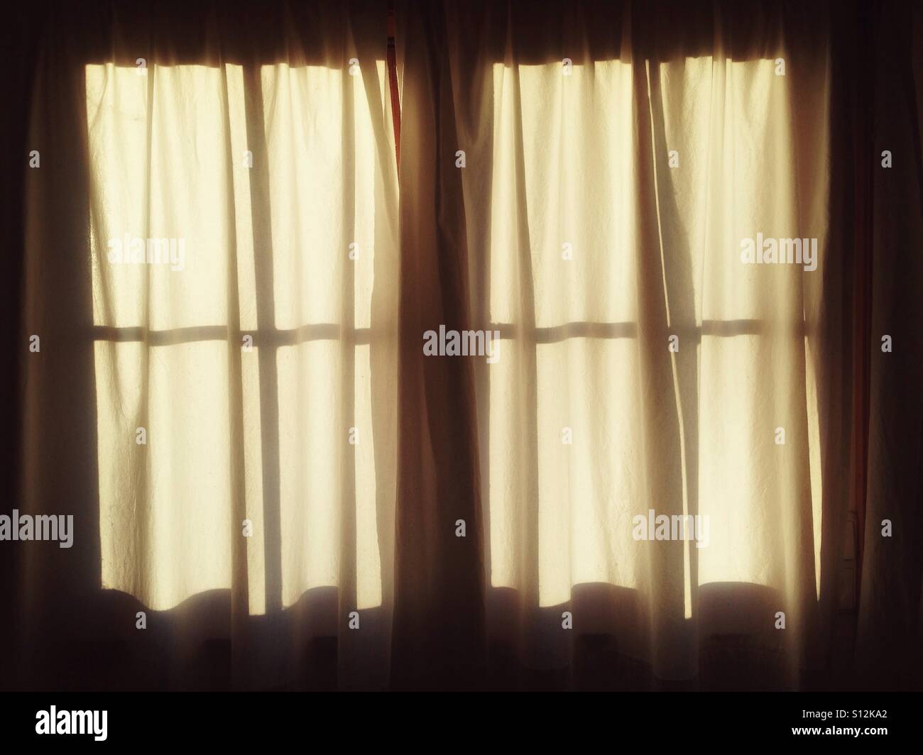 A transom window with white curtains in the soft light of the morning sun - Smartphone Captured Stock Image