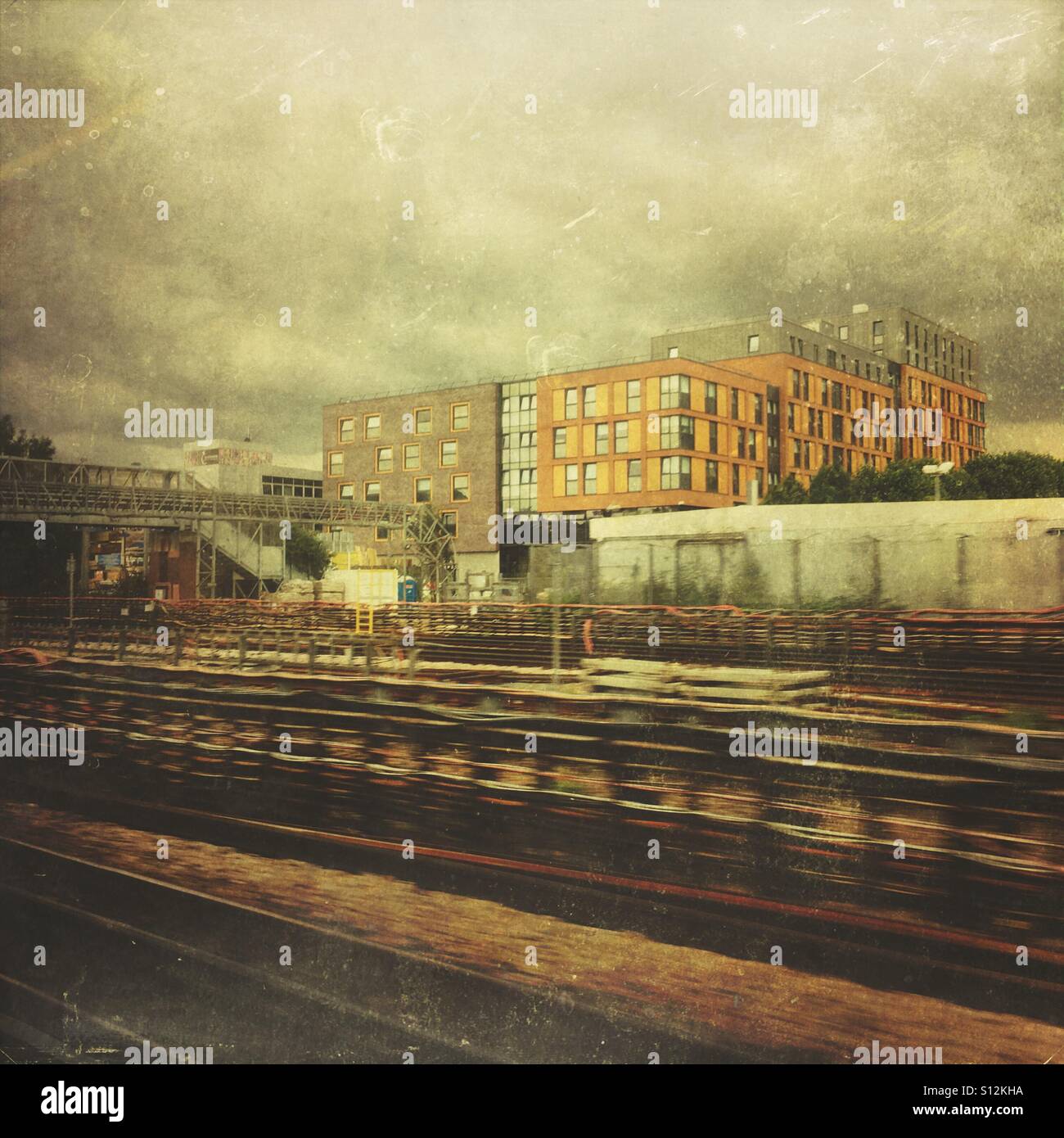Railway tracks at West Hampstead, London, England, UK. The tracks run through to Marylebone station. The new building alongside is the Nido student accommodation building. - Smartphone Captured Stock Image