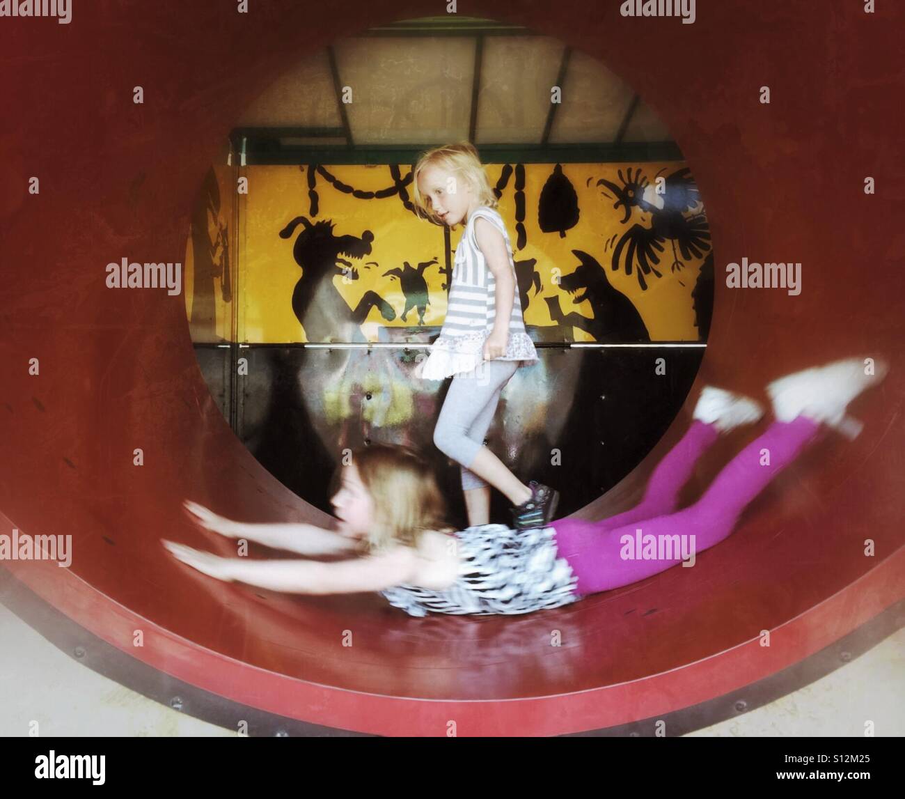 Two girls play in a fun house at a fair. - Smartphone Captured Stock Image