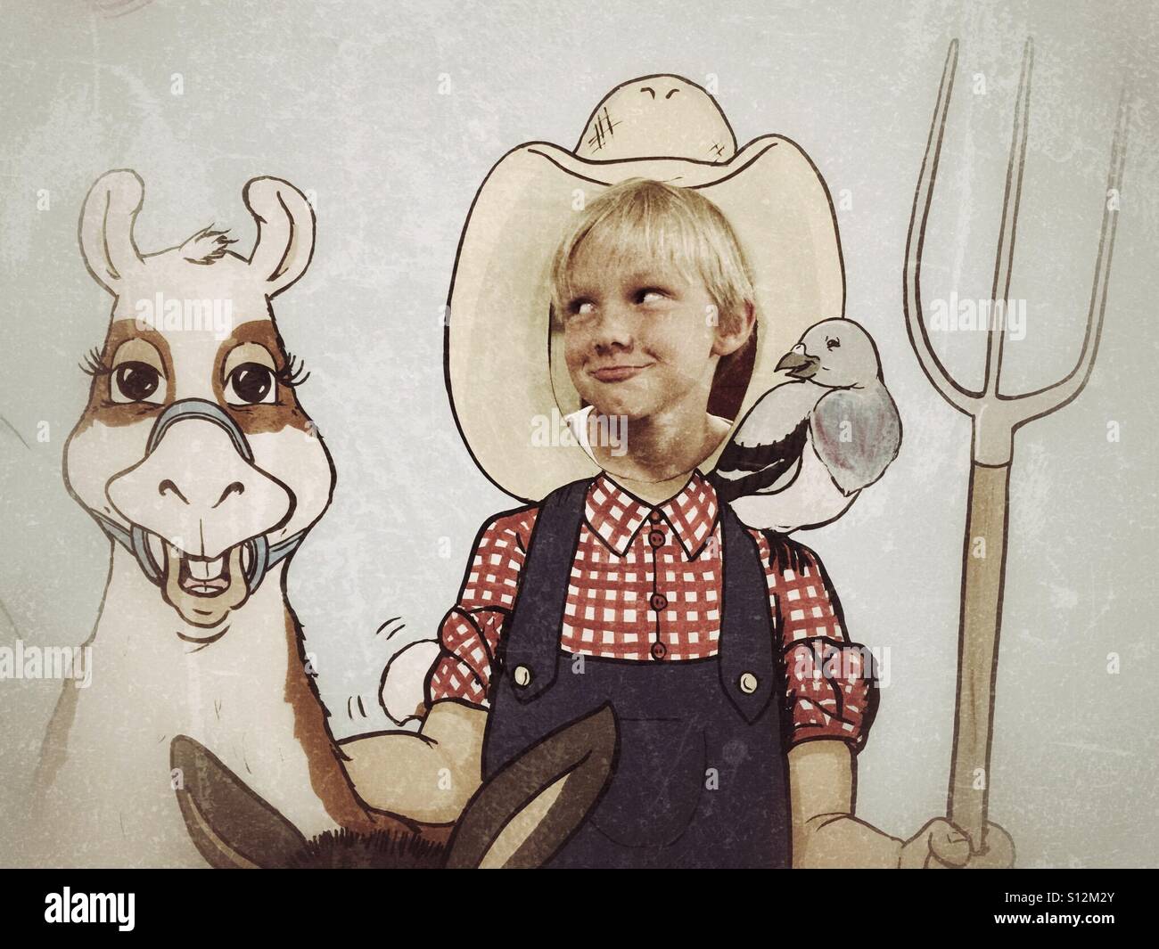 A boy smirks with his head through a cutout making him a llama farmer. - Smartphone Captured Stock Image