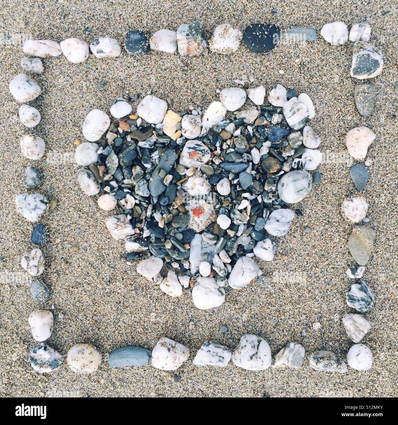 Heart made out of stones on a sandy beach Stock Photo