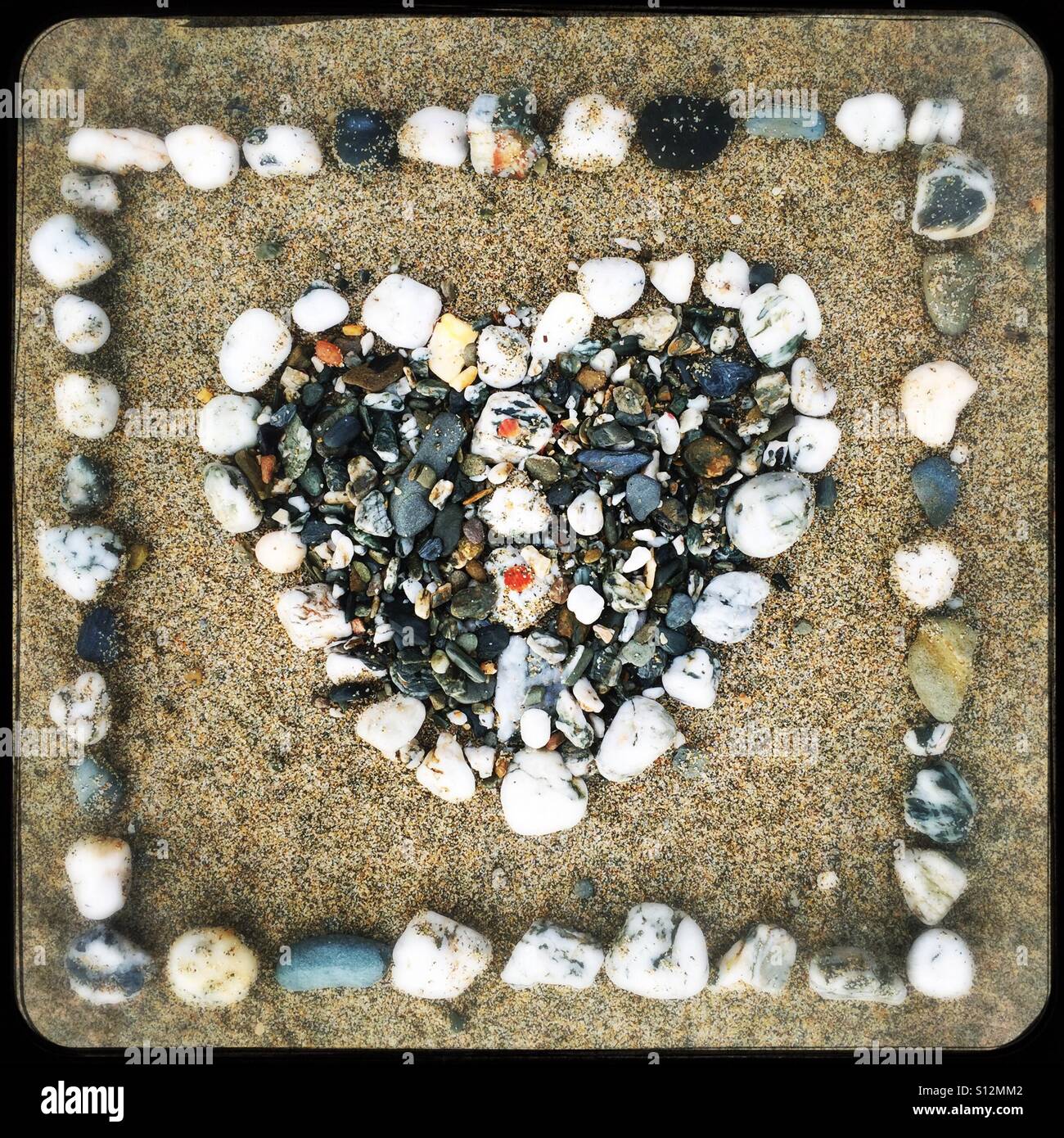Heart made of stones on a sandy beach Stock Photo