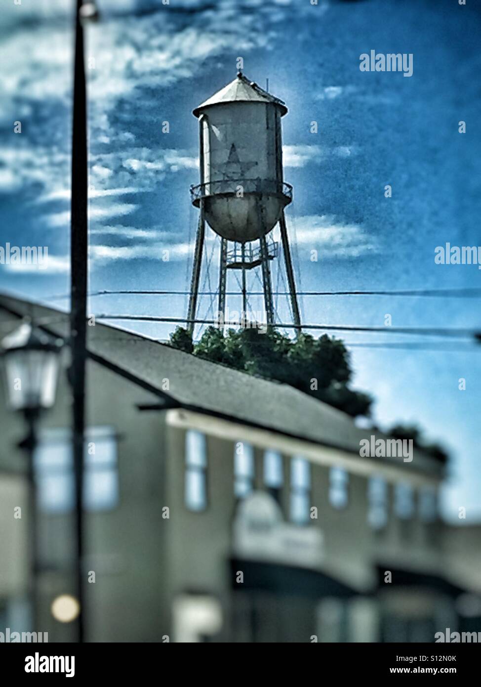 Water tower that has a star outlined with lights on the tank Stock Photo