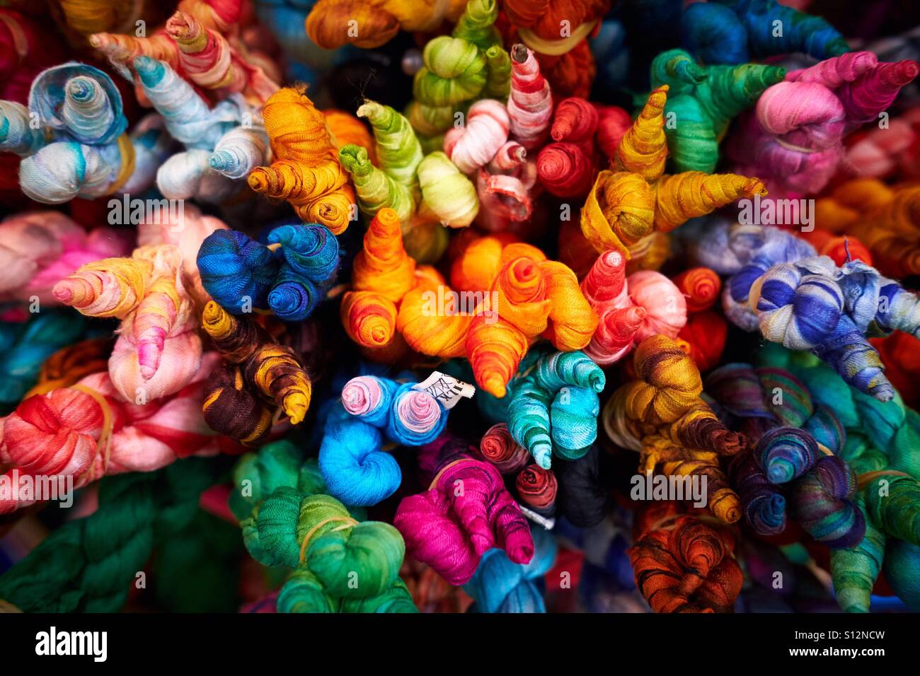 Colourful selection of twisted silk scarves packed together. Stock Photo