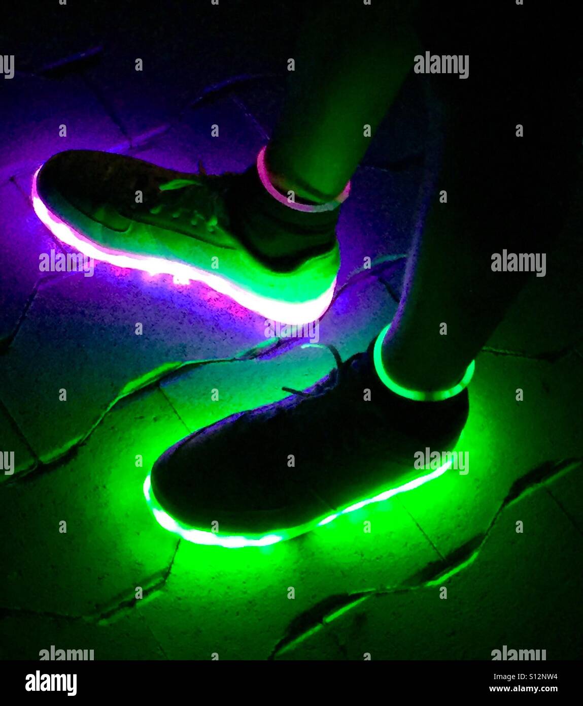 Close-Up of Glowing LED Shoes Illuminated in Darkness - Smartphone Captured Stock Image