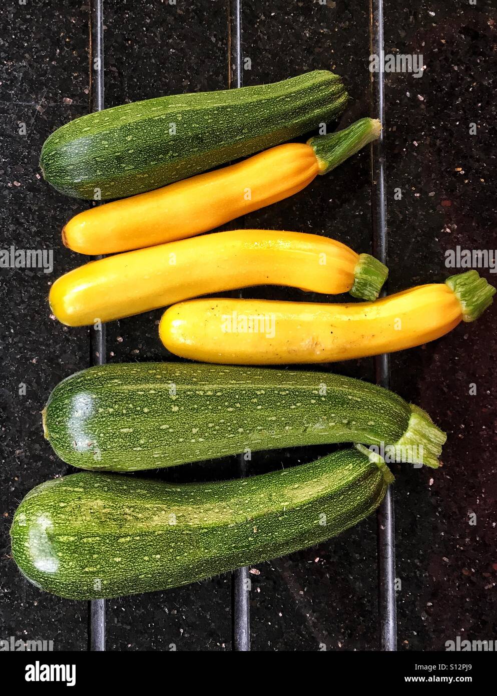 Green and yellow courgettes freshly picked from vegetable garden - Smartphone Captured Stock Image